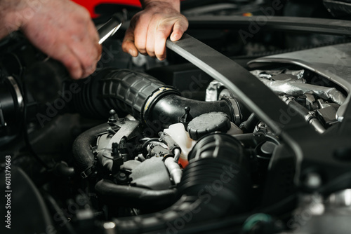 Auto mechanic checking engine in garage repair service