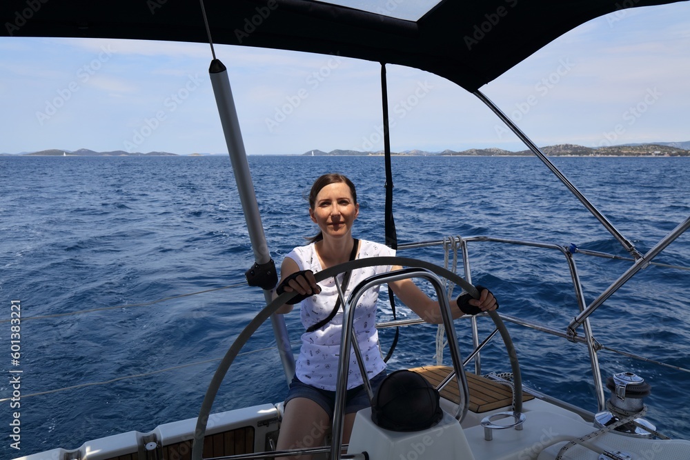 Naklejka premium Woman at the helm of Croatia sailboat