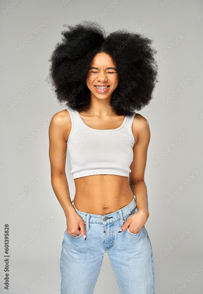 Portrait of smiling woman with braces on teeth and afro hairstyle isolated on gray background Portrait of smiling woman with braces on teeth and afro hairstyle isolated on gray background