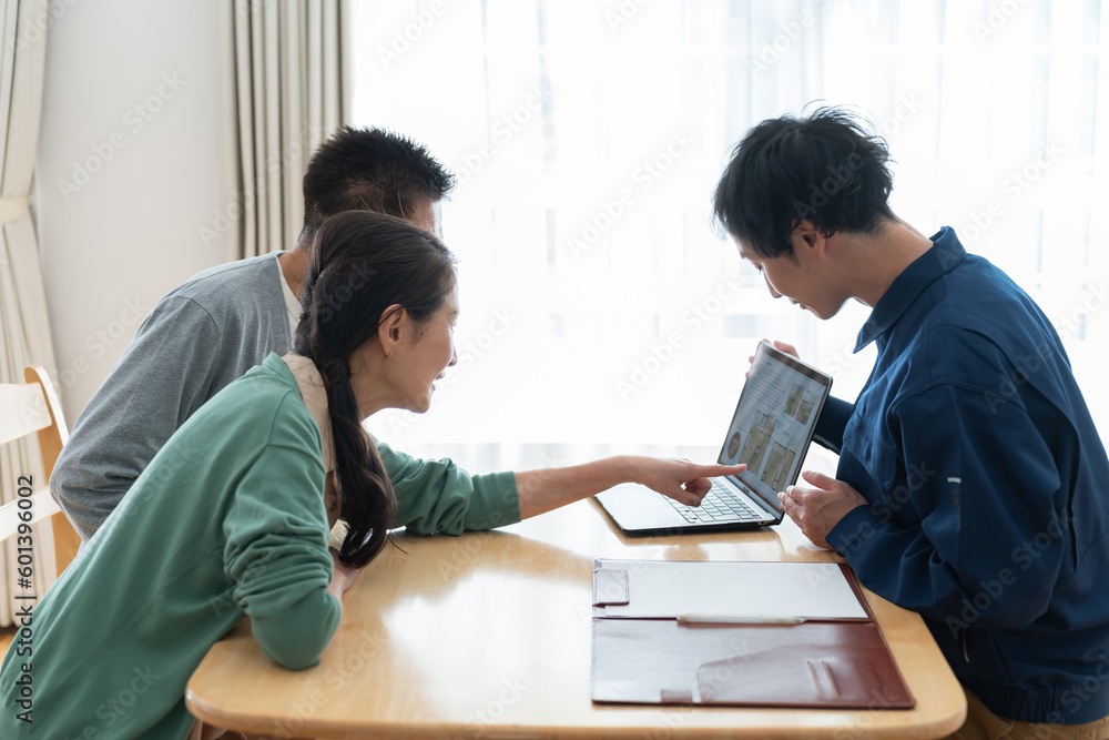 PCを見せながら説明をする日本人男性 PCを見せながら説明をする日本人男性