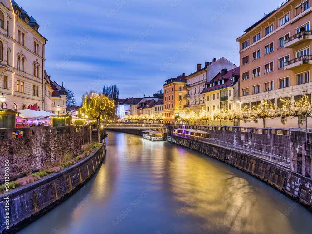 Ljubljana River and river side old town lit up with Christmas lights at dusk, Slovenia