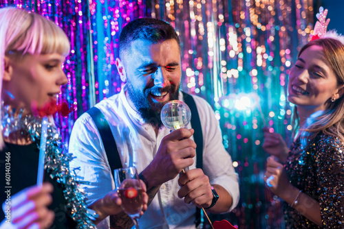 Group of people dancing in the club singing karaoke.