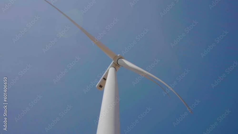 Windmill on blue sky background. Clean energy and sustainable future concept, Clean energy for environment, Clean renewable energy technologies, Large wind turbines producing clean sustainable energy Windmill on blue sky background. Clean energy and sustainable future concept, Clean energy for environment, Clean renewable energy technologies, Large wind turbines producing clean sustainable energy