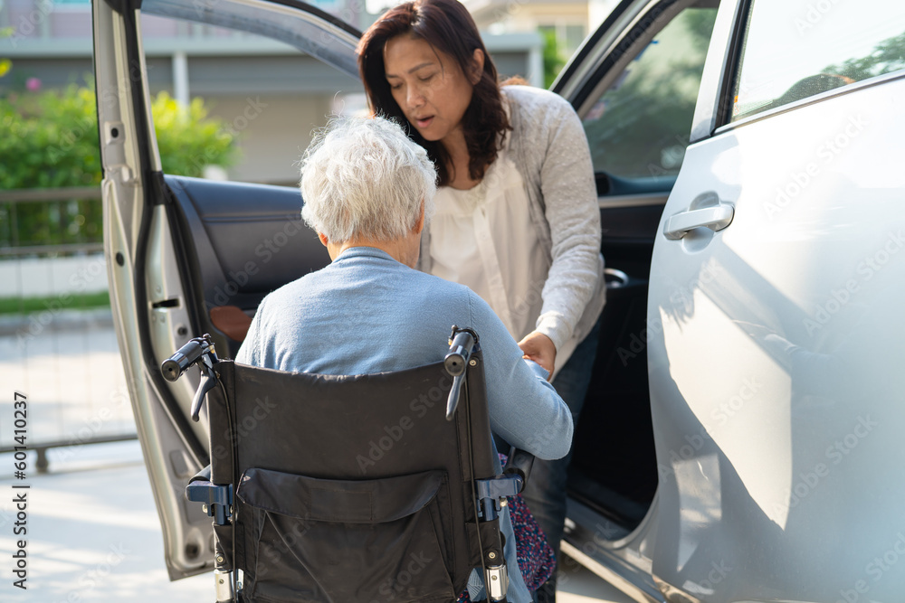 Caregiver help and support asian elderly woman sitting on wheelchair prepare get to her car to travel in holiday. Caregiver help and support asian elderly woman sitting on wheelchair prepare get to her car to travel in holiday.