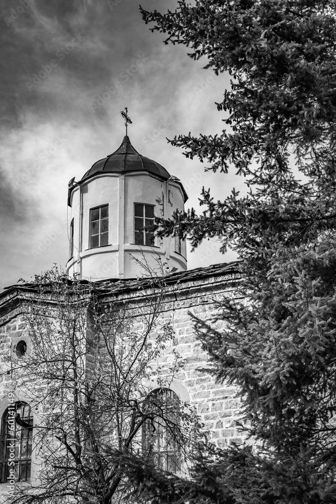 Travel, street perspectives from semi-abandoned village in Northern Bulgaria. Black and white picture. Christian Orthodox church top with cross.