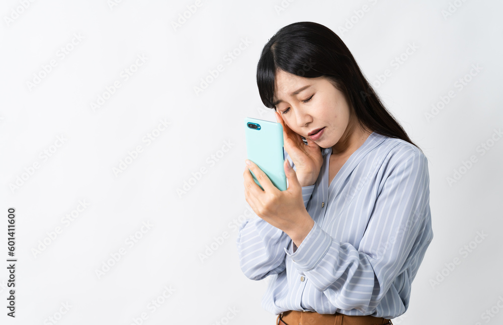 スマートフォンを持ちながらネガティブな表情をする若い女性