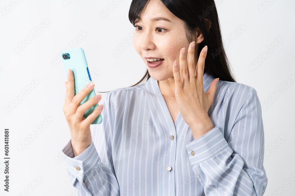 スマートフォンを持ちながらビックリをする若い女性 スマートフォンを持ちながらビックリをする若い女性