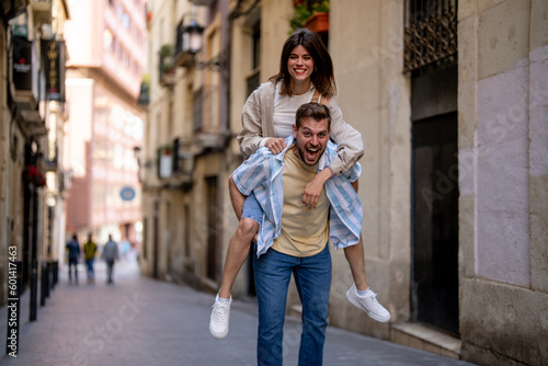 Young man carrying his girlfriend and enjoying a vacation with her 