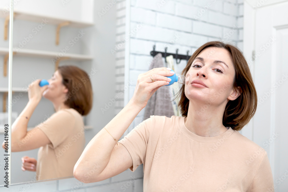 Young attractive woman doing facial massage with vacuum cups. Skin care and healthy lifestyle concept Young attractive woman doing facial massage with vacuum cups. Skin care and healthy lifestyle concept