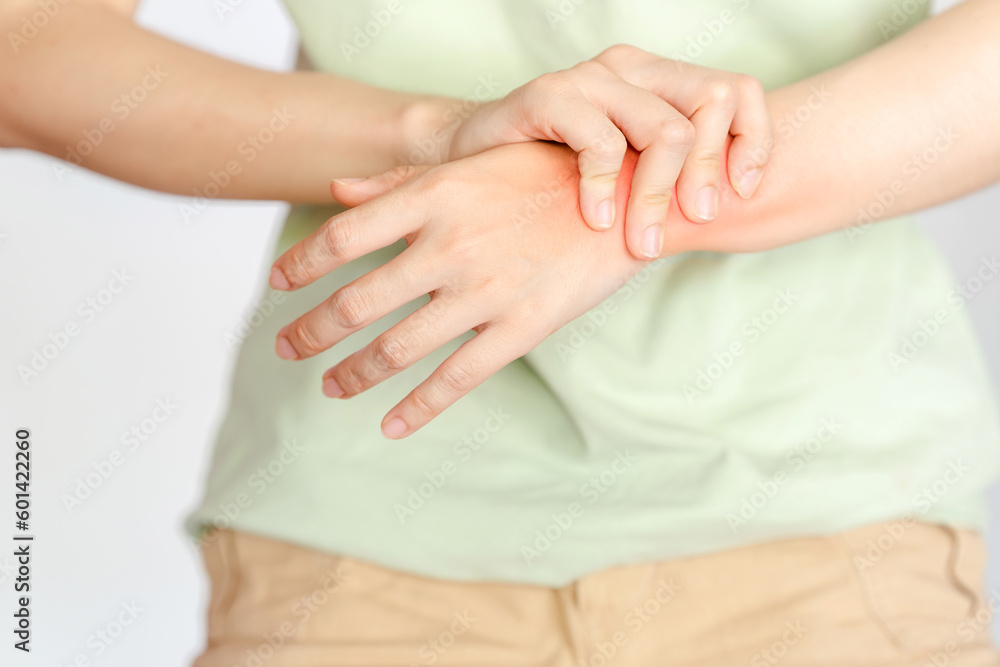 A woman holding her wrist due to an injury or rheumatoid arthritis. A woman holding her wrist due to an injury or rheumatoid arthritis.
