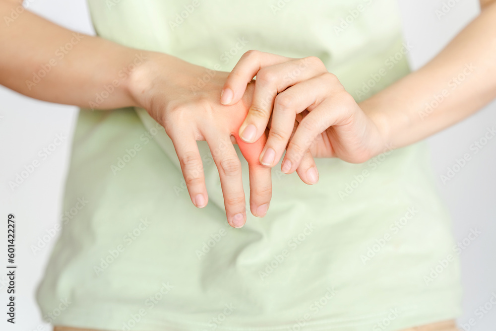 A woman touches her knuckle because of an injury or rheumatoid arthritis. A woman touches her knuckle because of an injury or rheumatoid arthritis.