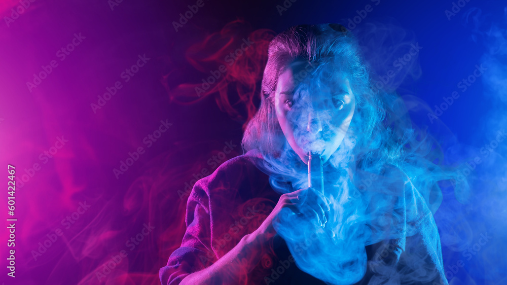 Woman smokes vape. Girl releases steam from device for vaping. Lady vaper. Woman with electronic cigarettes. Vaper on neon background. Vape pen for smoking vapor. Hobby vaping. Vape smoker Woman smokes vape. Girl releases steam from device for vaping. Lady vaper. Woman with electronic cigarettes. Vaper on neon background. Vape pen for smoking vapor. Hobby vaping. Vape smoker