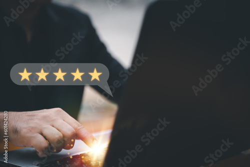 Customer service experience and business satisfaction survey.close up Man hand using smartphone with popup five star icon for feedback review satisfaction service.