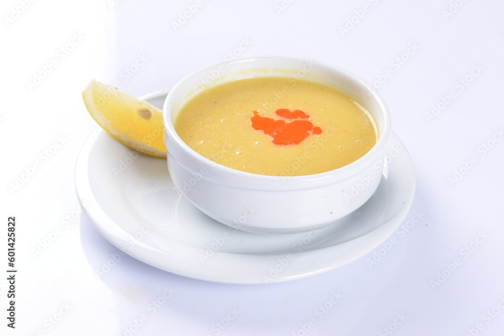 Lentil Soup with lemon and hot oil sauce, in white bowl Lentil Soup with lemon and hot oil sauce, in white bowl