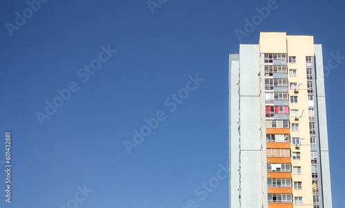 Multi-storey residential building against the background of clear blue sky.