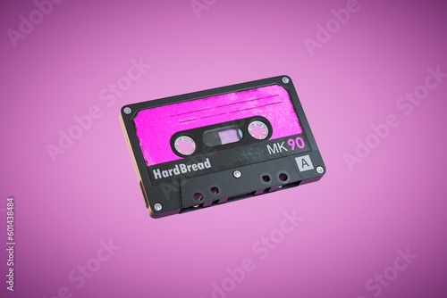 An old audio cassette on a pink background. 3D render