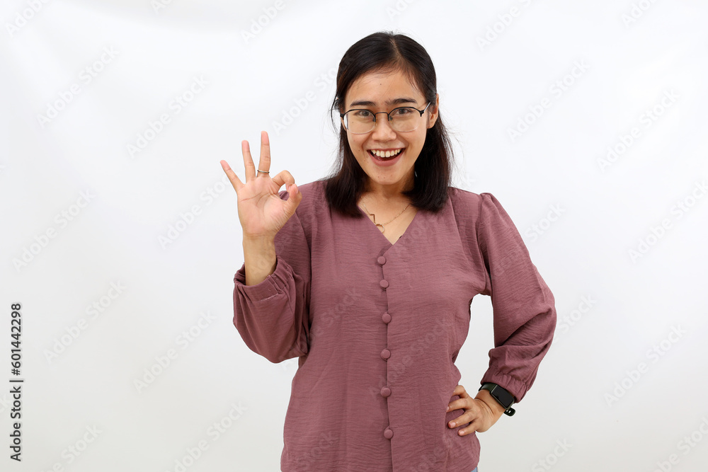Asian young woman showing okay hand gesture. Isolated on white Asian young woman showing okay hand gesture. Isolated on white