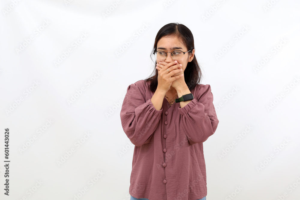 Young asian woman covering her mouth while glancing beside her. Isolated on white background Young asian woman covering her mouth while glancing beside her. Isolated on white background