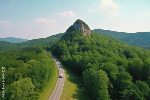 Car van rv driving on asphalt freeway to rocky peak of forestry mountain, road travel concept photo