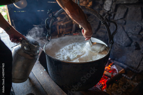 Bacówka w Jaworkach i okolice. Osoba nabierająca ugotowane mleko z garnka na ognisku. 