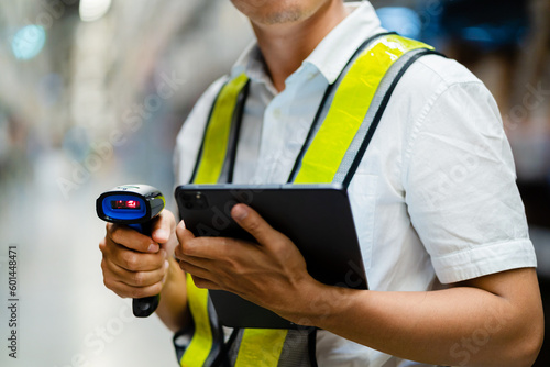 Close-up male engineer scanning goods with barcode scanner checking goods in transportation and distribution in warehouse. Industry and Export Business Concepts