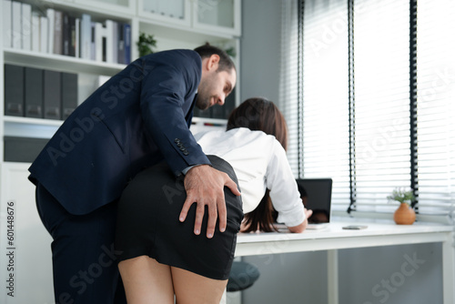 Caucasian businessman erotic touch Asian businesswoman when they meeting about project that sexual harassment in office company