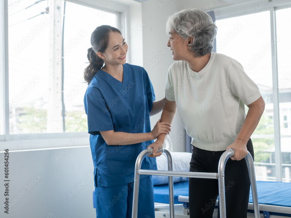 Fototapeta premium Asian senior care nurses and grandmothers provide caring support to elderly women hand clasp to encourage exercising with elder disabled person patient with caregiver in nursing care.