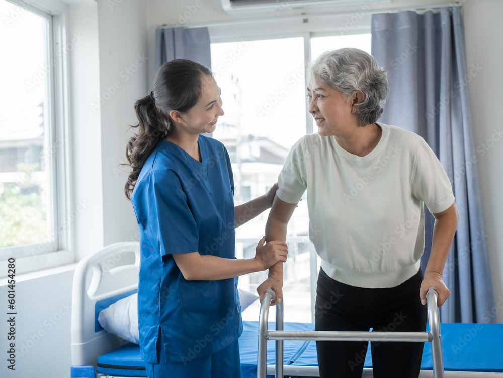 Fototapeta premium Asian senior care nurses and grandmothers provide caring support to elderly women hand clasp to encourage exercising with elder disabled person patient with caregiver in nursing care.