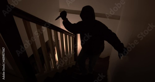 An assassin with a pocket knife sneaks into the house quietly up the stairs at night.