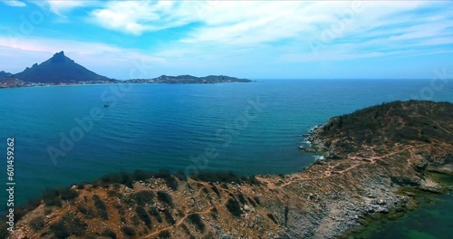 Strafe Pan Aerial with Island Trail, Large Bay, Distant Sailboat and Mountains in Background