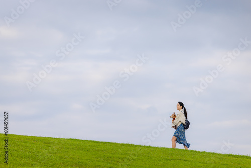 Woman with her dachshund dog walking in the park