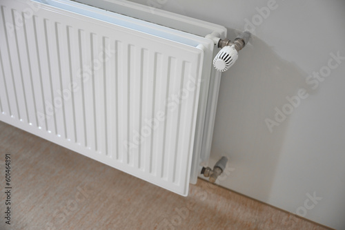 A white radiator attached to a wall, providing warmth and comfort to the room. Its smooth surface and neutral color blend seamlessly into the surrounding decor