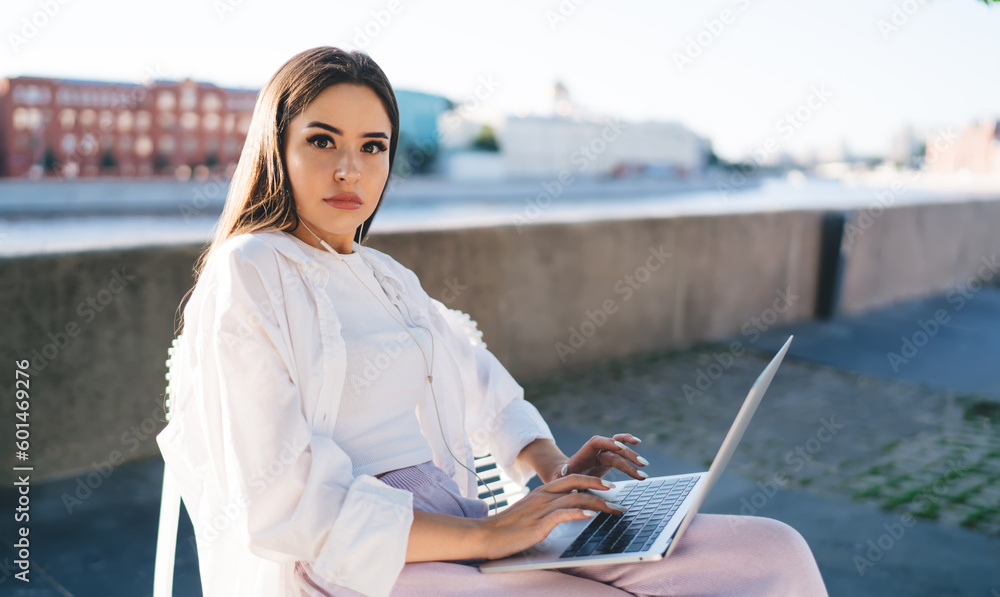 Woman working on netbook on city embankment