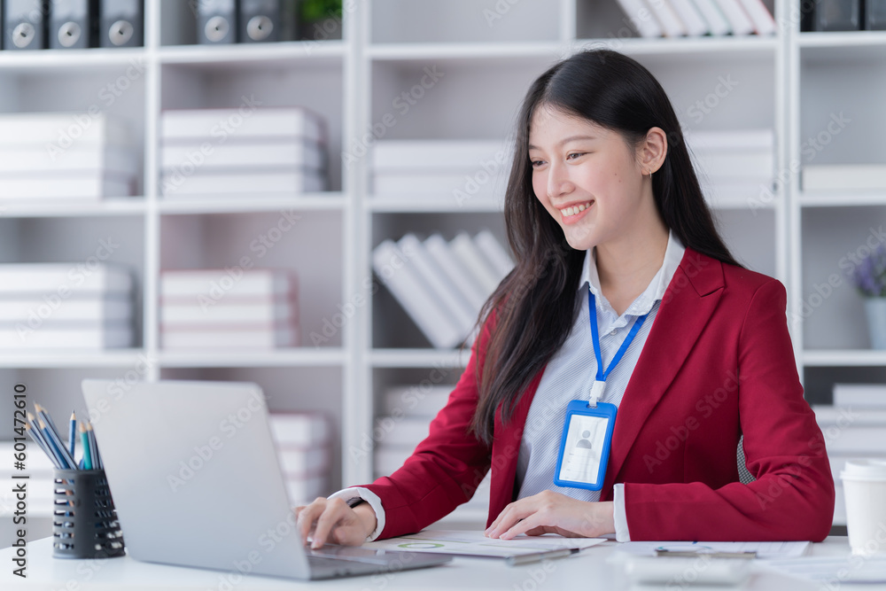 Sharing good business news. Attractive young businesswoman talking on the mobile phone and smiling while sitting at her working place in office and looking at laptop PC. Sharing good business news. Attractive young businesswoman talking on the mobile phone and smiling while sitting at her working place in office and looking at laptop PC.