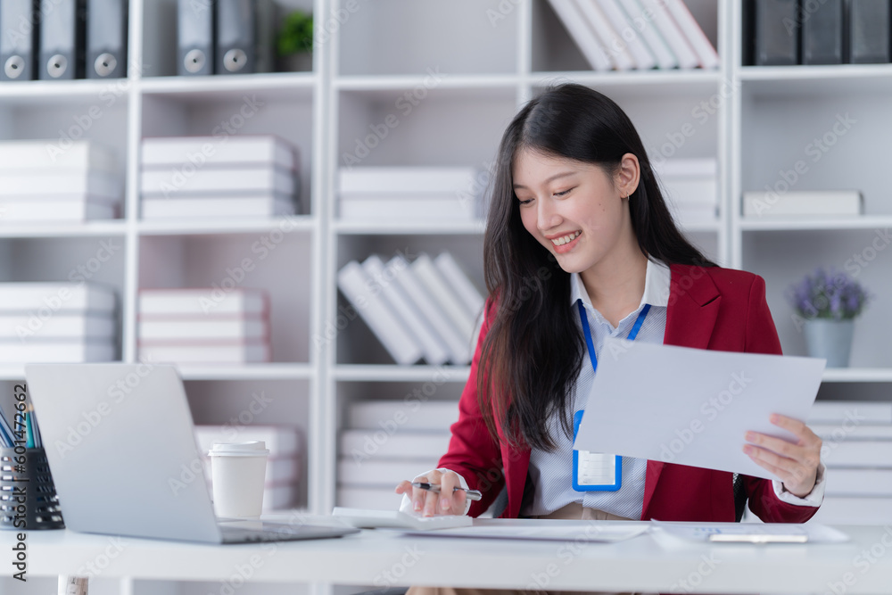 Portrait of young professional businesswoman writing on paper and use smartphone while sitting at office. Portrait of young professional businesswoman writing on paper and use smartphone while sitting at office.