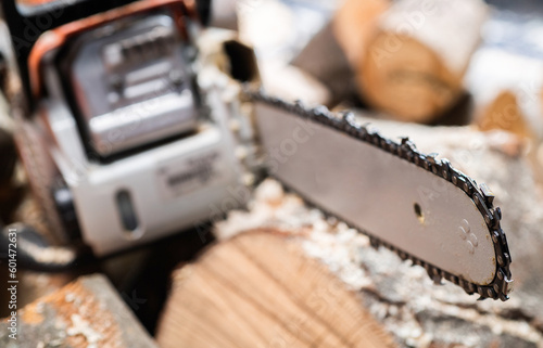 Foto Modern chain saw and  firewood