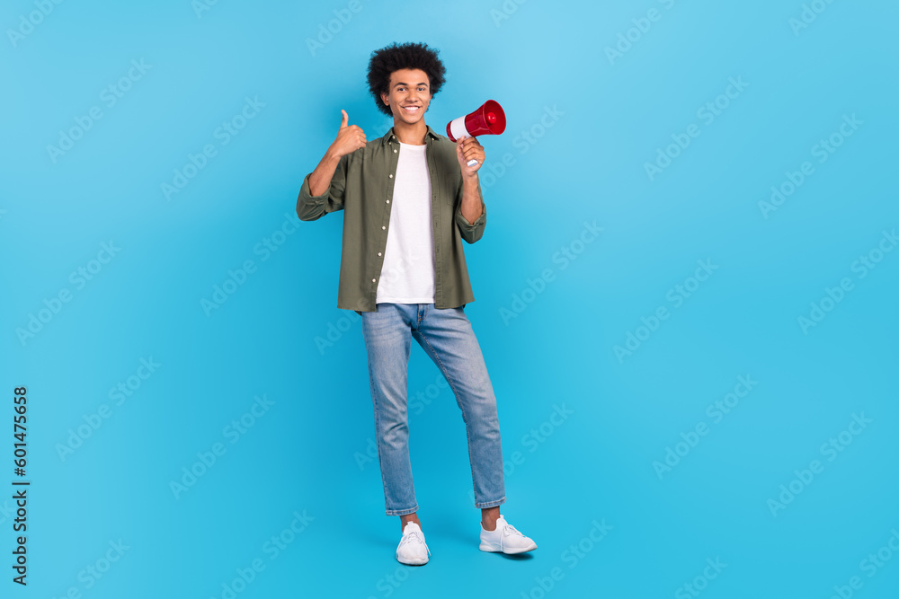 Full length size photo of young activist thumb up rate wear khaki shirt megaphone announce news speaker isolated on blue color background Full length size photo of young activist thumb up rate wear khaki shirt megaphone announce news speaker isolated on blue color background