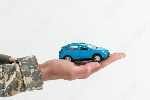 a military man is holding a toy car photo