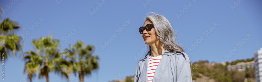 Urban lady strolling in modern outfit on city street