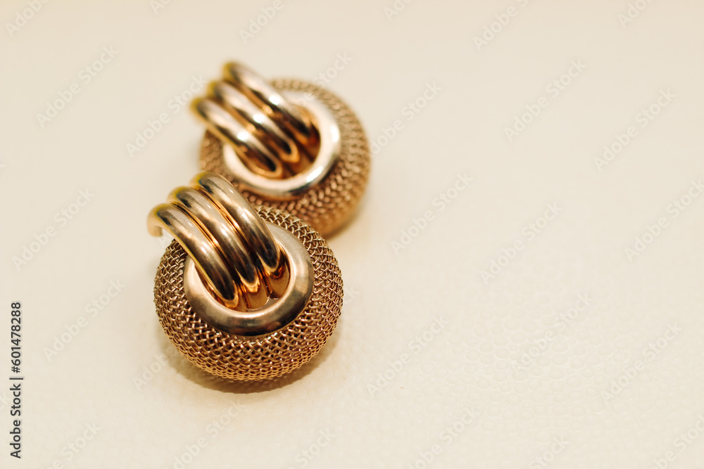Gold ornaments from yellow metal on a light background. Gold ornaments from yellow metal on a light background.