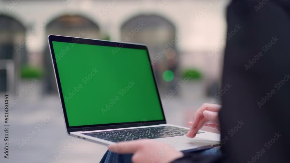 Young Girl Using Green Mock-up Screen Laptop on Street Young Girl Using Green Mock-up Screen Laptop on Street