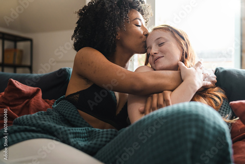 Loving Embrace: Multiracial Lesbian Couple Share Tender Moment on Couch