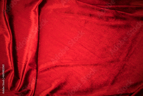 Fold soft waved red velour fabric textured background.