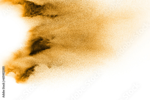 Golden sand explosion isolated on white background. Abstract sand cloud.Sandy fly wave in the air. photo
