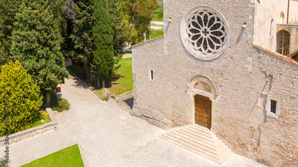 Aerial view of Valvisciolo Abbey, a Cistercian monastery located in Sermoneta, in the province of Latina, Italy. The church has a rose window and is a masterpiece of Romanesque-Cistercian architecture Aerial view of Valvisciolo Abbey, a Cistercian monastery located in Sermoneta, in the province of Latina, Italy. The church has a rose window and is a masterpiece of Romanesque-Cistercian architecture