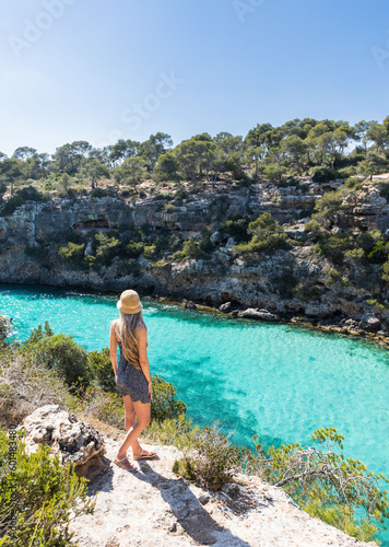 Obraz na plátně Rear view of blonde woman with hat in cala pi, mallorca, balearic islands