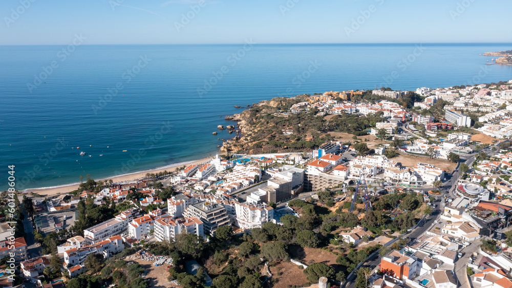 Aerial photo of the beautiful town in Albufeira in Portugal showing the Praia da Oura golden sandy beach, with hotels and apartments in the town, taken on a summers day in the summer time.
