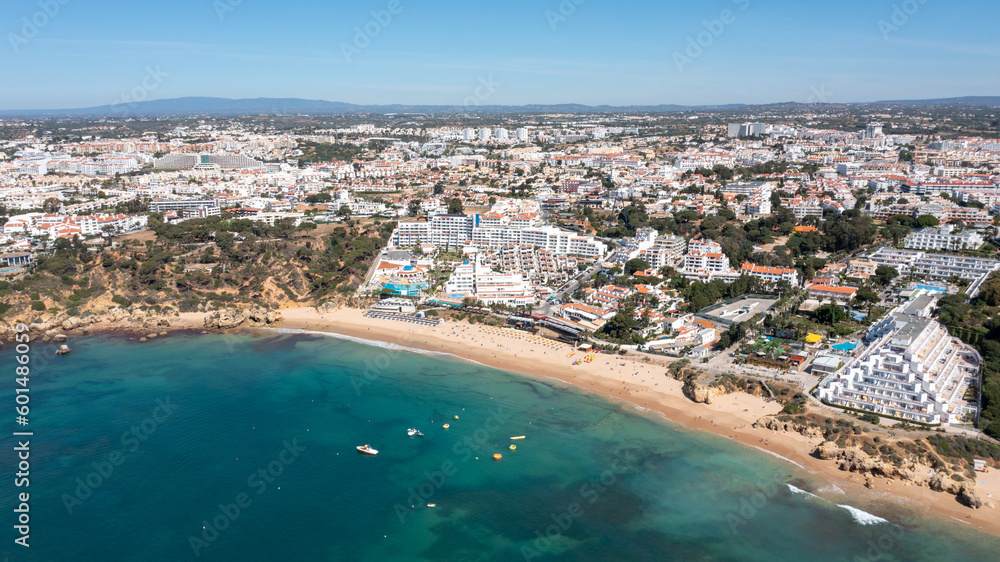 Aerial photo of the beautiful town in Albufeira in Portugal showing the Praia da Oura golden sandy beach, with hotels and apartment in the town, taken on a summers day in the summer time.