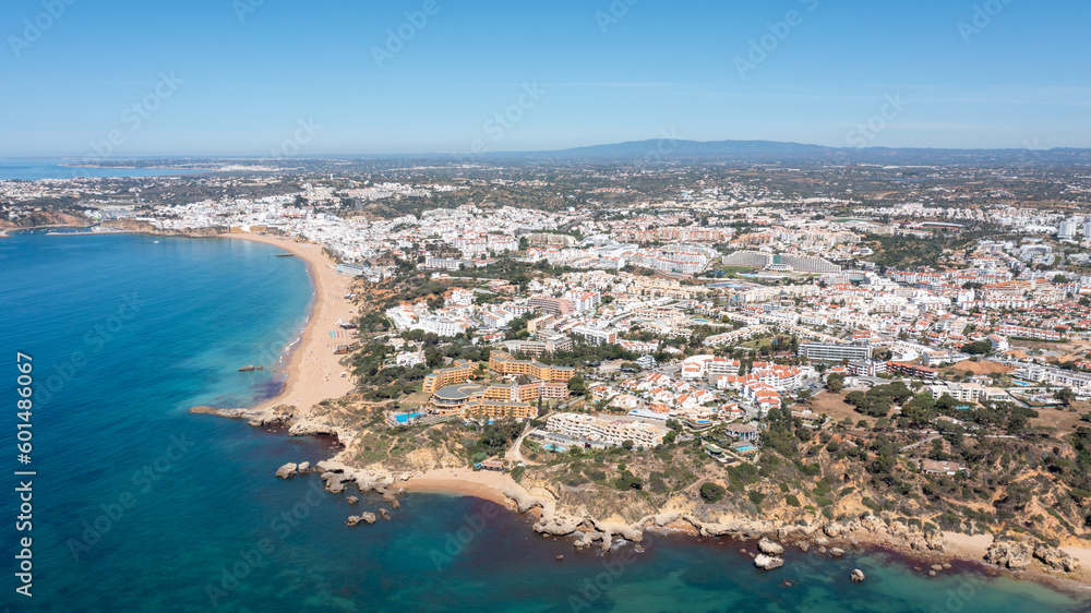 Aerial photo of the beautiful town in Albufeira in Portugal showing the Praia de Albufeira golden sandy beach, with hotels and apartments in the town, taken on a summers day in the summer time. Aerial photo of the beautiful town in Albufeira in Portugal showing the Praia de Albufeira golden sandy beach, with hotels and apartments in the town, taken on a summers day in the summer time.