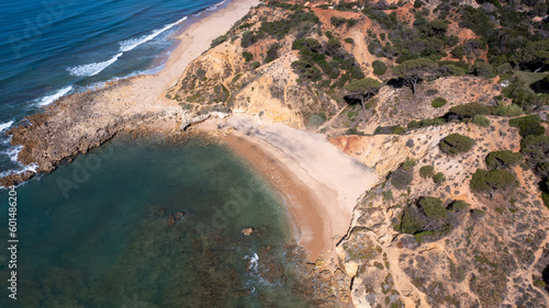 Aerial photo of the beautiful beach in Albufeira in Portugal showing a secluded beach by the ocean on a hot sunny day in the summer time.